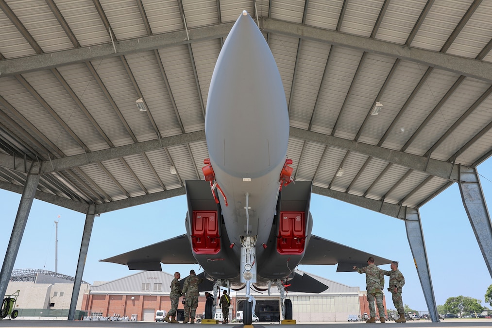 Service members tour an aircraft as it sits on the flight line.