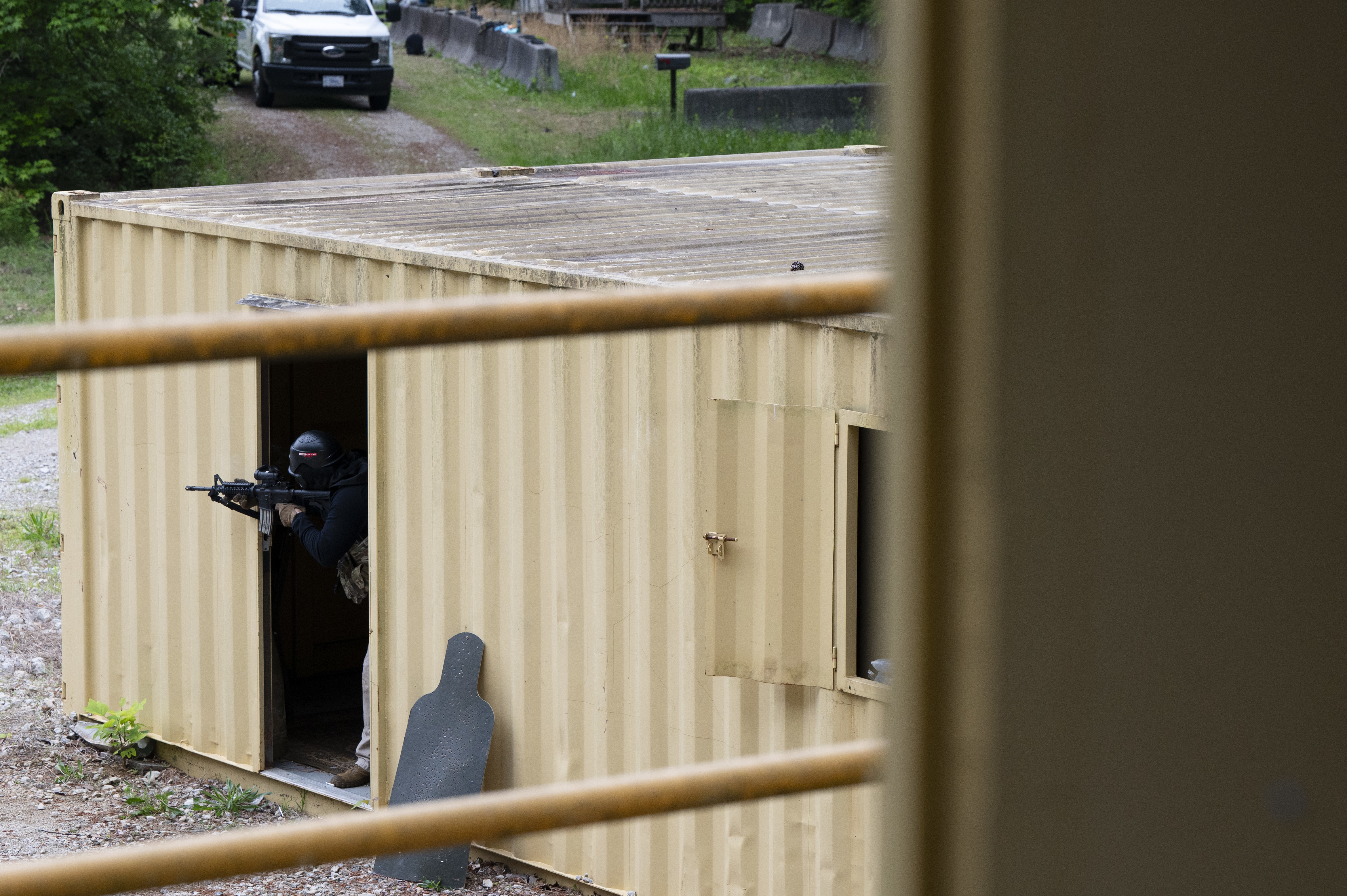 A U.S. Air Force 94th Security Forces Squadron response force member acting as opposing forces aims a weapon toward other response force members at Dobbins Air Reserve Base, Ga., May 7, 2025, during a training exercise. Friendly-fire scenarios using simulated munitions illustrate the operational risks associated with poor communication in confined spaces, allowing Defenders to hone their skills without the risk of harming other Airmen. (U.S. Air Force photo by Staff Sgt. Gage Daniel)