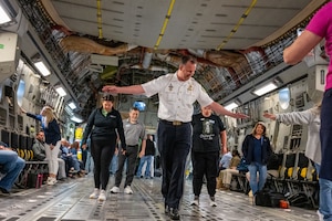 Chief Thomas Johnson, 436th Security Forces Squadron honorary commander and Dover Police Department chief of police, attempts to walk a straight line during turbulence on a C-17 Globemaster III orientation flight at Dover Air Force Base, Delaware, June 10, 2025.