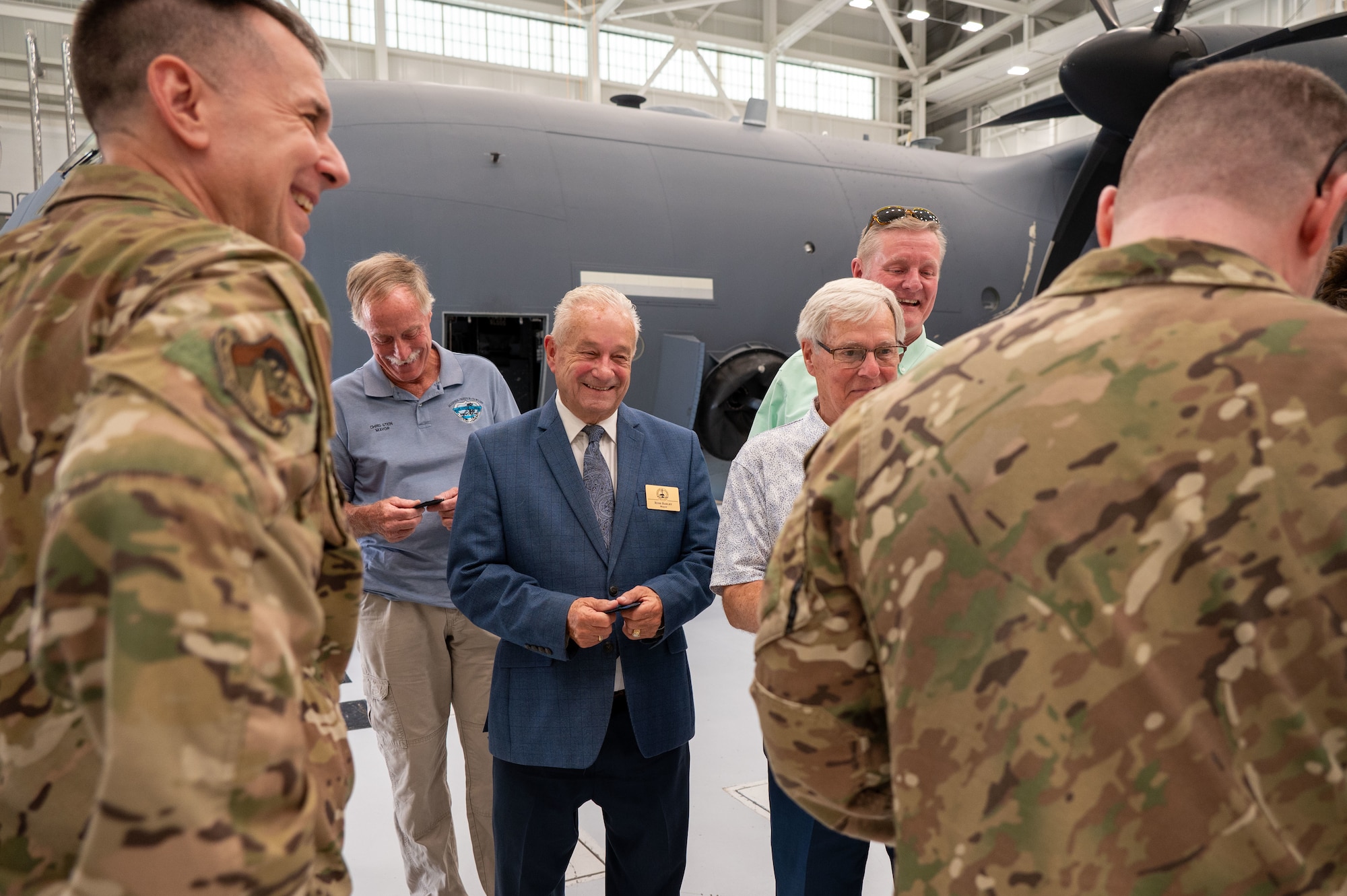Mayors from around Florida's Emerald Coast receive a patch from a squadron attached to the 919th Special Operations Wing in front of an AC-130J on May 30, 2025. The purpose of the visit was to acquaint civic leaders with the unique mission of the 919th Special Operations Wing.
