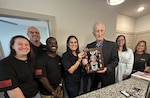 Members of AFPC’s Personnel Support Directorate pose with retired Tech. Sgt. Frank Hollestelle, after presenting him a shadow box April 18, 2025 in Cibolo, Texas. Hollestelle’s military records were lost while processing a request to have his medals replaced. Members from the recognitions section were able to rebuild his official military records using copies he made more than 75 years ago. (U.S. Air Force photo by Phillip Ulmer)
