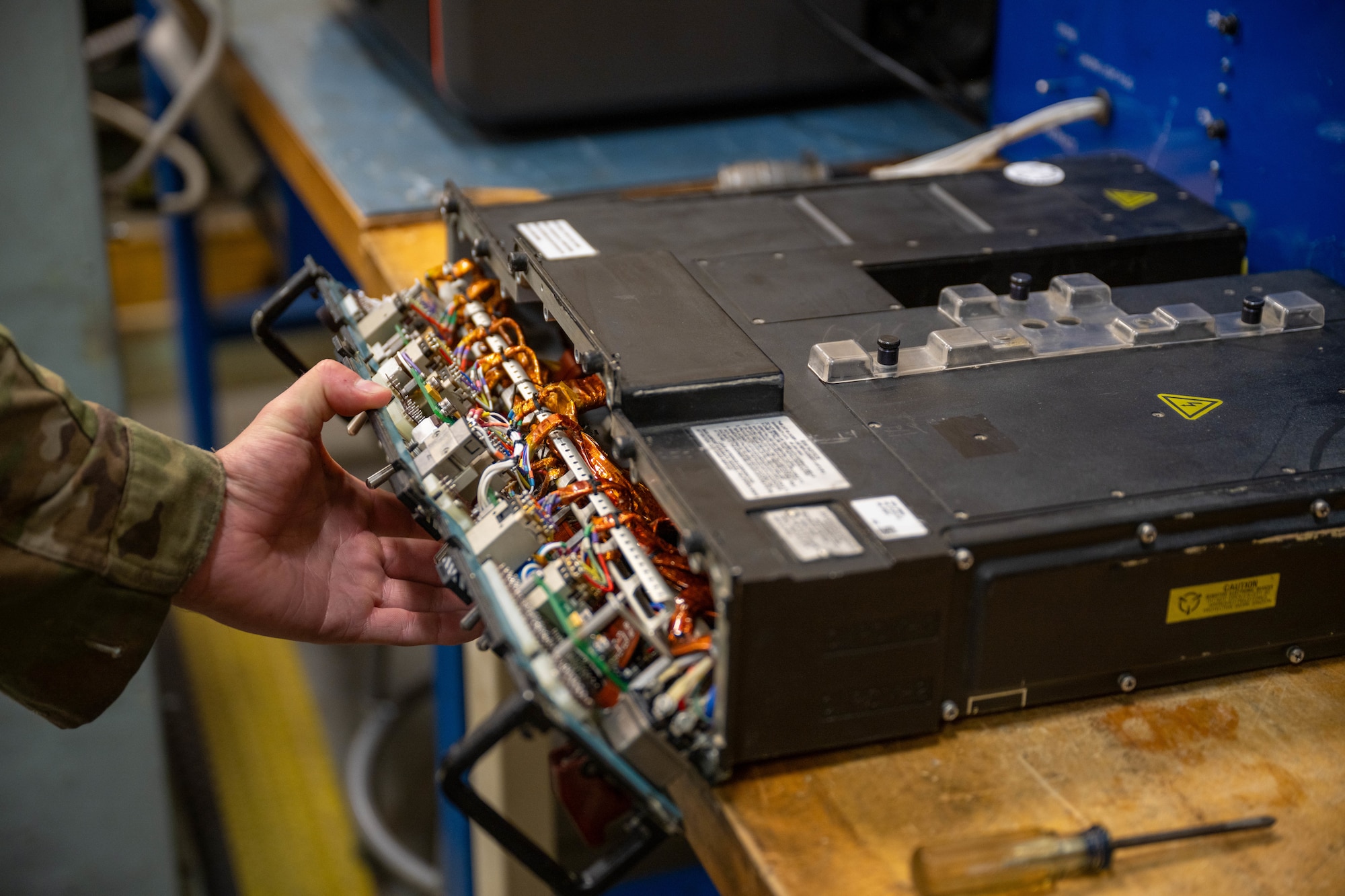 A man opens the face of an integrated fuel management panel (IFMP) for repair