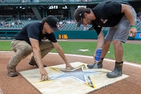 Staff of the Indianapolis Indians paint an Army Star logo behind home plate at Victory Field in Indianapolis June 14, 2025. Eighteen Future Soldiers took the Oath of Enlistment before the game, which paid special tribute to the Army's 250th birthday. (U.S. Army photo by Mark R. W. Orders-Woempner)