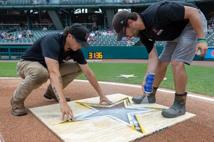 Staff of the Indianapolis Indians paint an Army Star logo behind home plate at Victory Field in Indianapolis June 14, 2025. Eighteen Future Soldiers took the Oath of Enlistment before the game, which paid special tribute to the Army's 250th birthday. (U.S. Army photo by Mark R. W. Orders-Woempner)