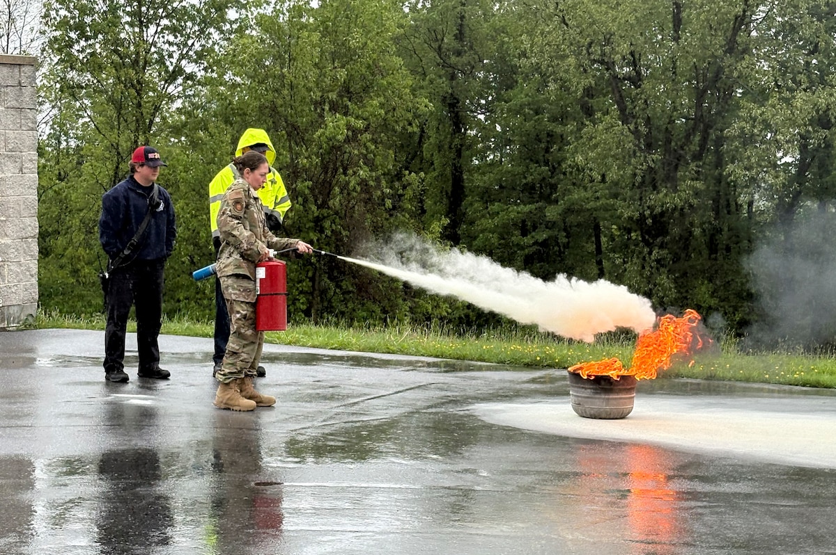 Photo of Guardsman extinguishing a small fire.