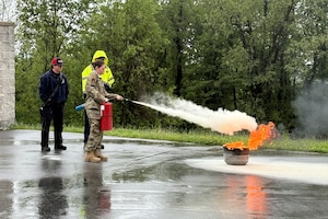 Photo of Guardsman extinguishing a small fire.