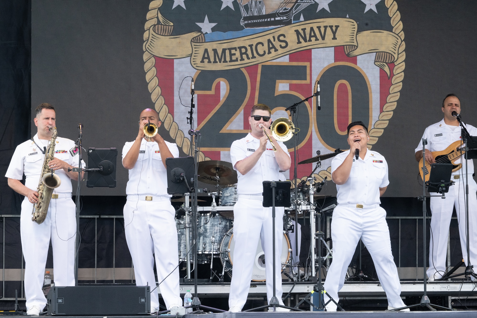 The U.S. Navy Band Cruisers popular music group performs on Speed Street of Charlotte Motor Speedway ahead of the Coca-Cola 600. An estimated 100,000 fans annually attend the 400 lap 600 mile NASCAR Cup Series points race over Memorial Day weekend in what is known as one of the biggest weekends in auto racing. The Cruisers are one of the Navy Band’s most musically versatile groups, able to reach audience members of all ages with classic rock to funk and Top 40 covers, connecting them to their United States Navy and the Sailors deployed around the world keeping our nation safe and free.  (U.S. Navy photo by Petty Officer 1st Class April Enos)
