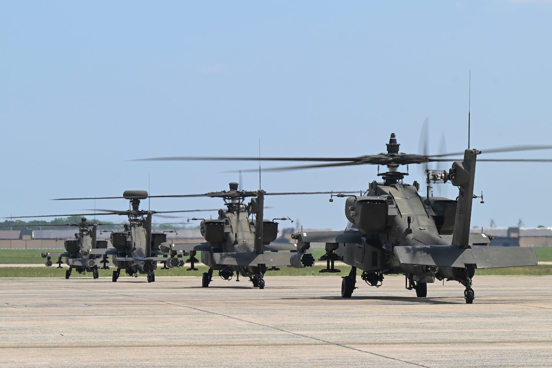 U.S. Army AH-64 Apache helicopters assigned to the 82nd Combat Aviation Brigade park on the flight line.