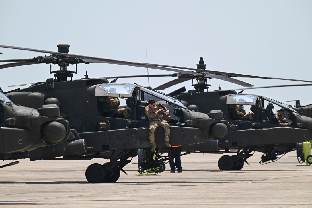 AH-64E Apache Guardian helicopters assigned to the 82nd Combat Aviation Brigade sit on the flight line.