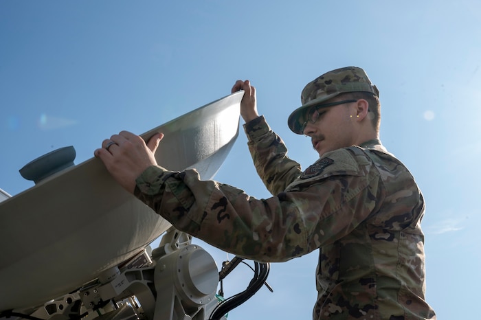 U.S. Air Force Airman 1st Class Brayden Walling, 92nd Communications Squadron radio frequency transmission technician, moves an antenna pedestal assembly at Fairchild Air Force Base, Washington, June 2, 2025.  The Global Aircrew Strategic Network Terminal system uses extremely high frequency and advanced EHF waveforms to provide protected communication capabilities in operational environments. (U.S. Air Force photo by Airman 1st Class Samantha Thorn)