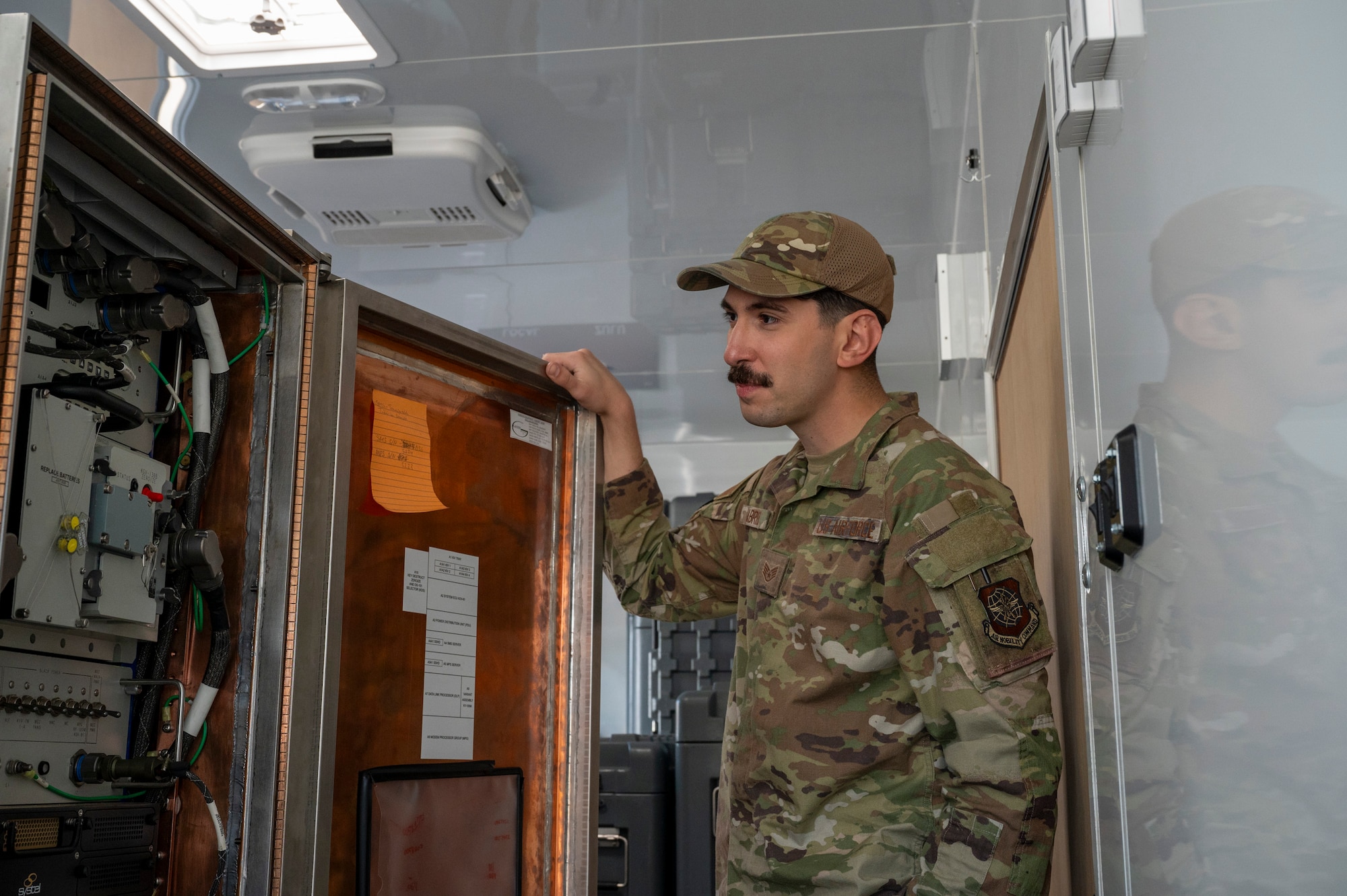 U.S. Air Force Staff Sgt. Joao Gabriel, 92nd Communications Squadron radio frequency operations noncommissioned officer in charge, inspects an equipment control unit at Fairchild Air Force Base, Washington, June 2, 2025. The ECU handles message traffic concurrently with encryption and decryption tasks. (U.S. Air Force photo by Airman 1st Class Samantha Thorn)