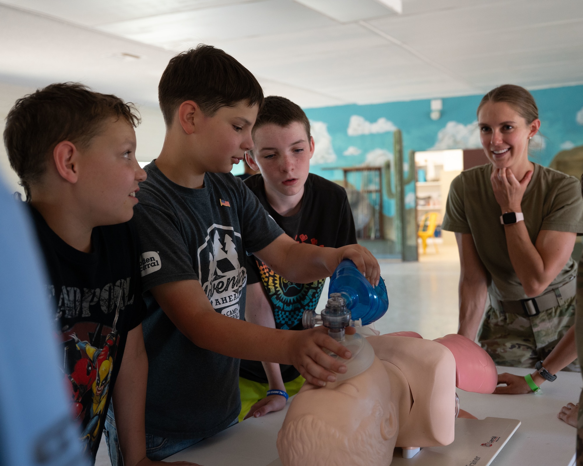YMCA Triangle Y Ranch campers simulate inflating lungs on a training aid at Oracle, Arizona, June 12, 2025. Airmen showed how their career fields support combat capability and base operations through hands-on demonstrations. (U.S. Air Force photo by Senior Airman Jasmyne Bridgers-Matos)