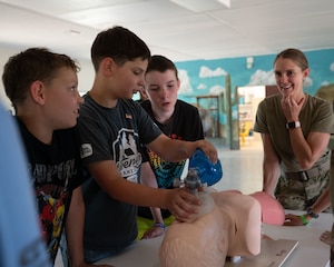 YMCA Triangle Y Ranch campers simulate inflating lungs on a training aid at Oracle, Arizona, June 12, 2025. Airmen showed how their career fields support combat capability and base operations through hands-on demonstrations. (U.S. Air Force photo by Senior Airman Jasmyne Bridgers-Matos)