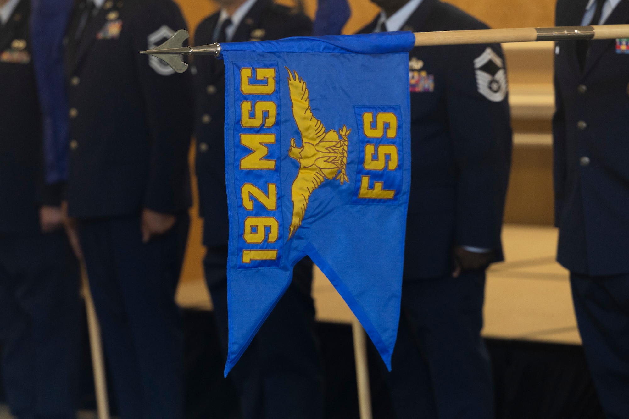 Senior leaders from the 192nd Mission Support Group stand in a row holding guidons for the flights and squadrons with the 192nd Force Support Squadron guidon unveiled.
