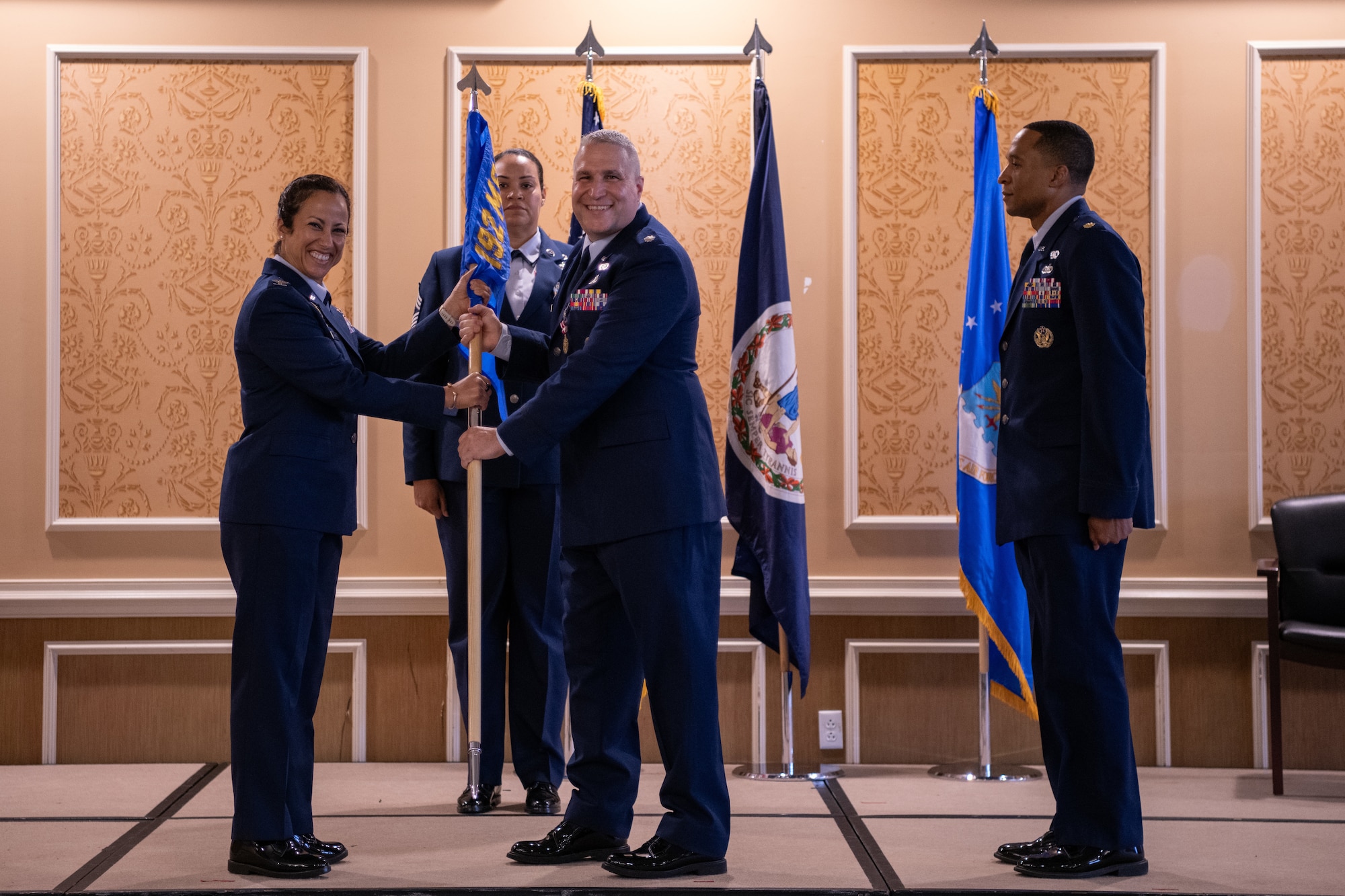Lt. Col. Alex J. Shamp, center, hands the 192nd Force Support Squadron guidon to Col. Manaal I. Burge.