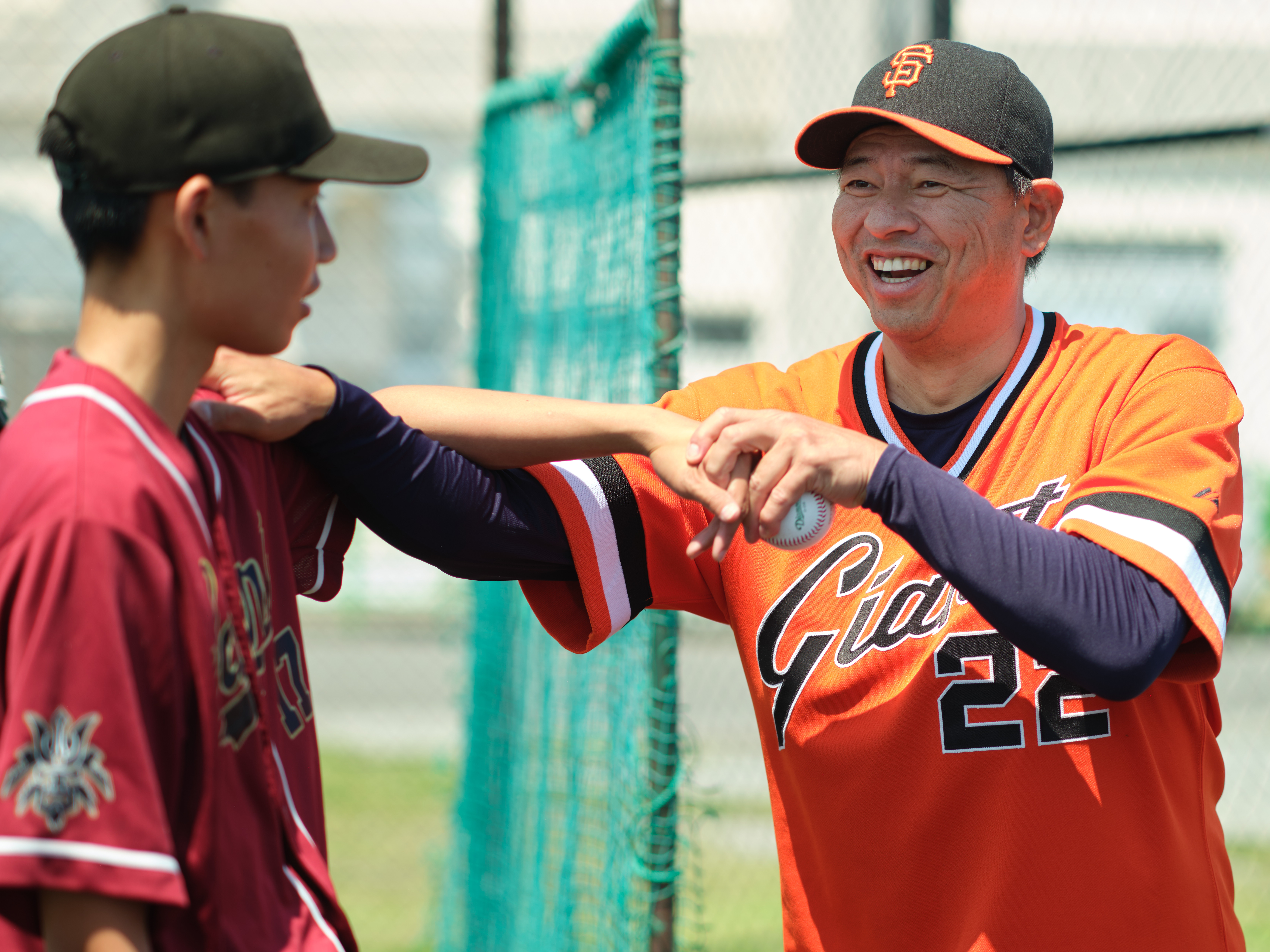 Former Major League Baseball (MLB) and Nippon Professional Baseball (NPB) star pitcher Keiichi Yabu coaches Aira Fujinuma, a  pitcher from Marine Corps Air Station Iwakuni's M.C. Perry High School, at the 10th Annual Far East All-Stars and Pro Scouting Combine June 1, 2025 at Commander, Fleet Activities Yokosuka's (CFAY) Berkey Field.