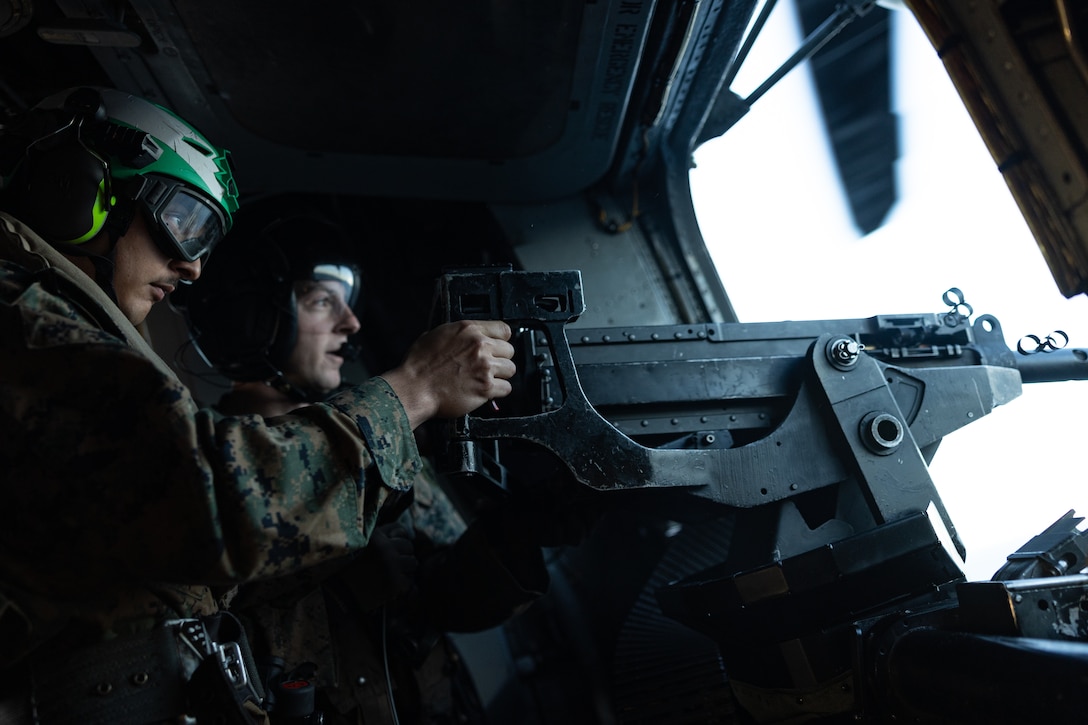 A U.S. Marine with the 31st Marine Expeditionary Unit, fires a 50. caliber machine gun while on a CH-53E Super Stallion helicopter assigned to Marine Medium Tiltrotor Squadron (VMM) 265 (Rein.) during flight operations, in the Coral Sea, June 12, 2025. Marines demonstrate the lethal capabilities of the 31st MEU by conducting routine areal patrols. The 31st MEU is operating aboard ships of the USS America Amphibious Ready Group in the 7th Fleet area of operations, the U.S. Navy’s largest forward-deployed numbered fleet, and routinely interacts and operates with allies and partners in preserving a free and open Indo-Pacific region. (U.S. Marine Corps photo by Lance Cpl. Gerardo Mendez)