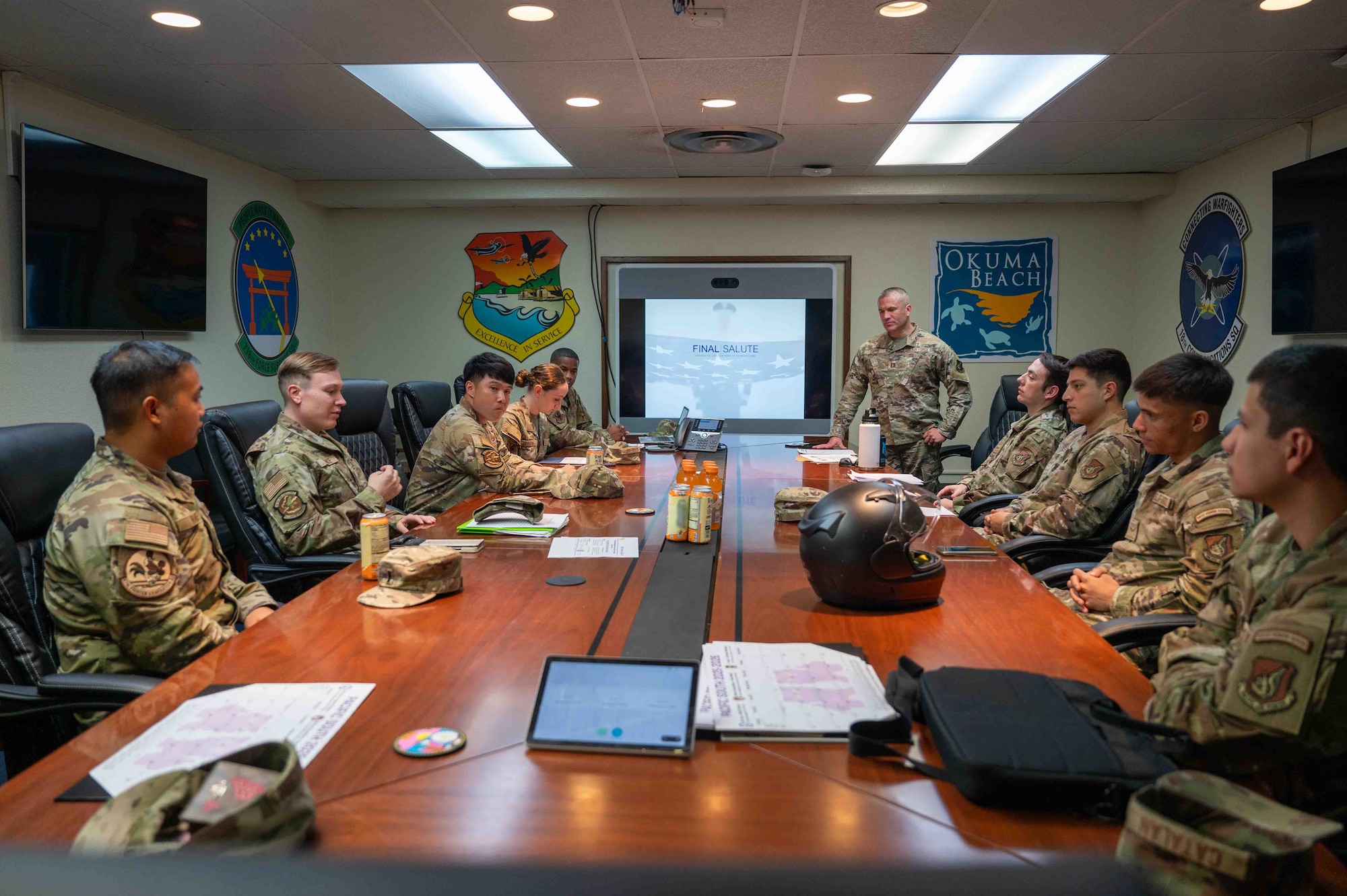 Service members sit in the table conversing with each other.