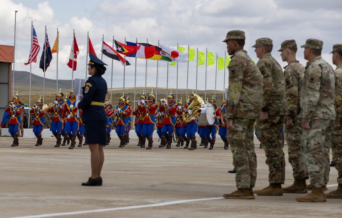 U.S. Army Soldiers assigned to 11th Military Police Brigade, 200th Military Police Command, watch the Armed Forces of Mongolia service members assigned to the Military Band of the General Staff play music during the opening ceramony for Khaan Quest 2025, on June 14, 2025, at Five Hills Training Area, Mongolia.