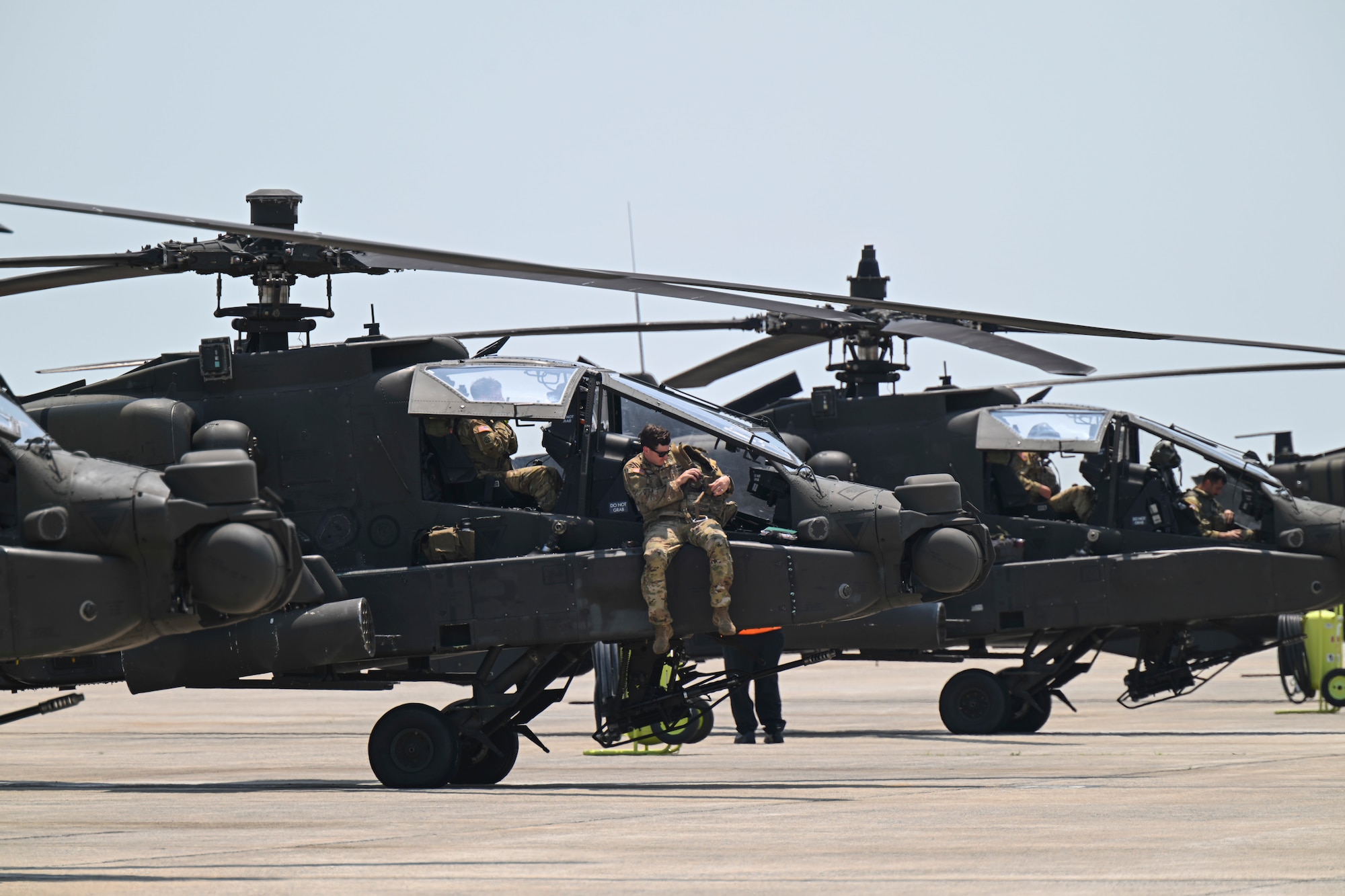AH-64E Apache Guardian helicopters assigned to the 82nd Combat Aviation Brigade sit on the flight line.