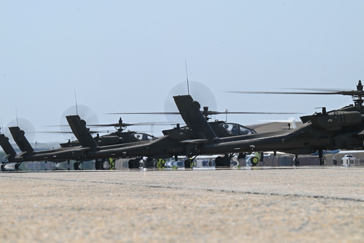 U.S. Army AH-64E Apache Guardian helicopters assigned to the 82nd Combat Aviation Brigade stage on the flight line.