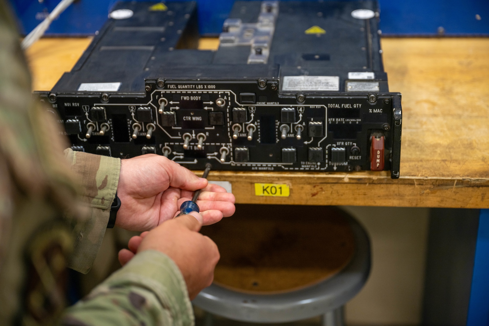 A man repairs an integrated fuel management panel.