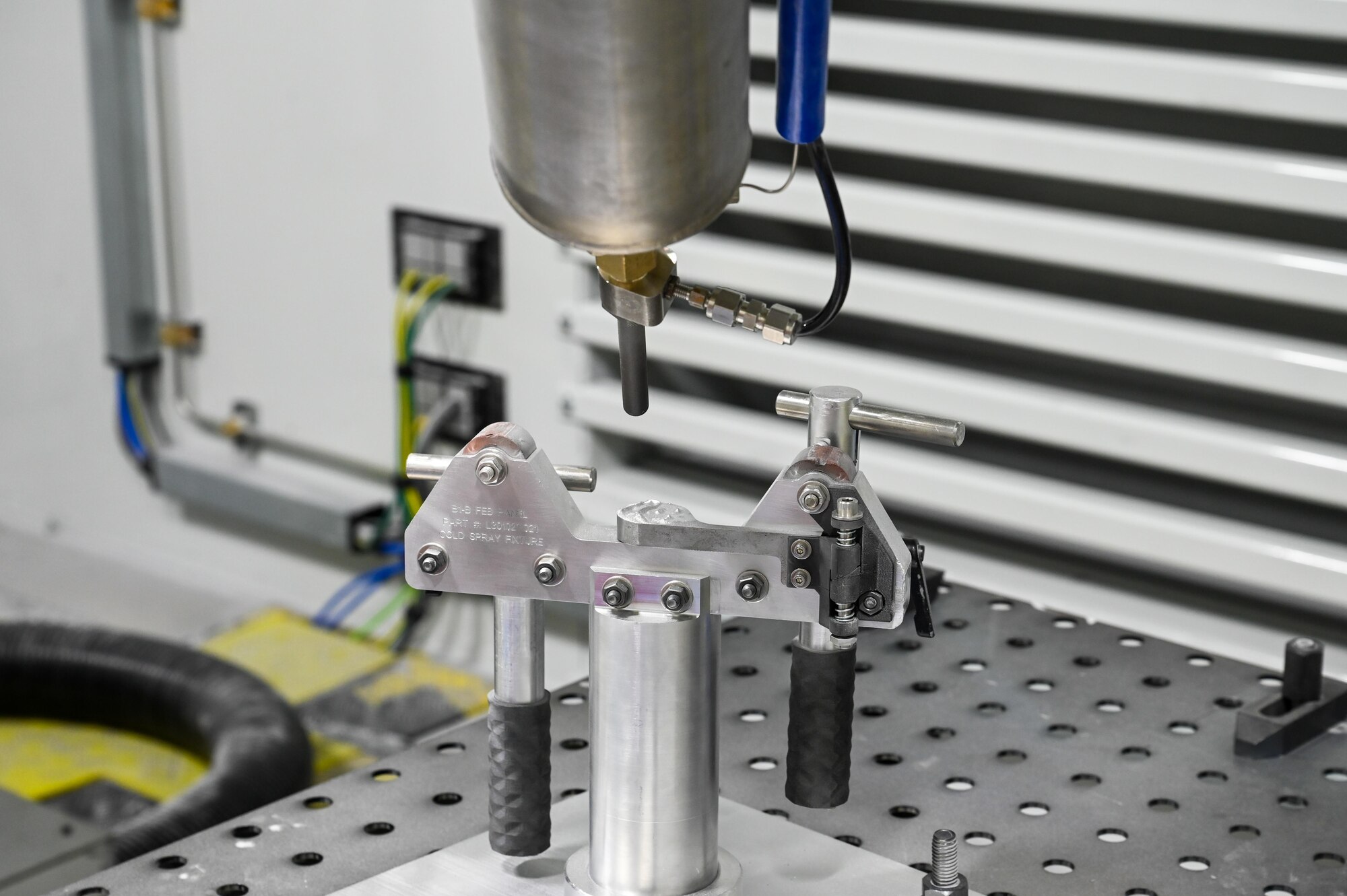 The Centerline SST EPX spray system nozzle assembly demonstrates simulated hole repair at ES3’s Cold Spray Repair Development Center, Abilene, Texas, May 20, 2025. The nozzle mixes heated gas and metal powder then propels the material onto a metal surface. (U.S. Air Force photos by Airman 1st Class Adrien Tran)