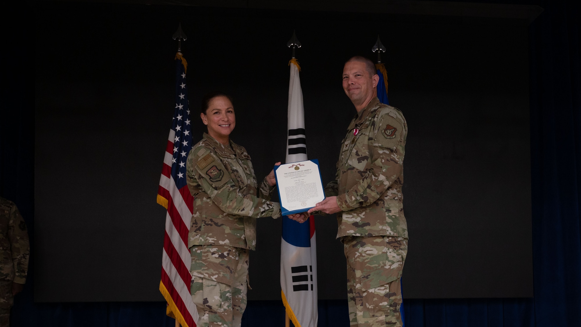 U.S. Air Force Col. Jamie Cornett, right, outgoing 51st Operational Medical Readiness Squadron commander, right, receives the Meritorious Service Medal from Col. Mocha Robinson, 51st Medical Group commander, left, during a Change of Command ceremony at Osan Air Base, Republic of Korea, June 17, 2025. The award recognized Cornett’s leadership of the squadron responsible for the medical readiness of 24,000 warfighters, dependents and DoD civilians. (U.S. Air Force photo by Senior Airman Rome Bowermaster)