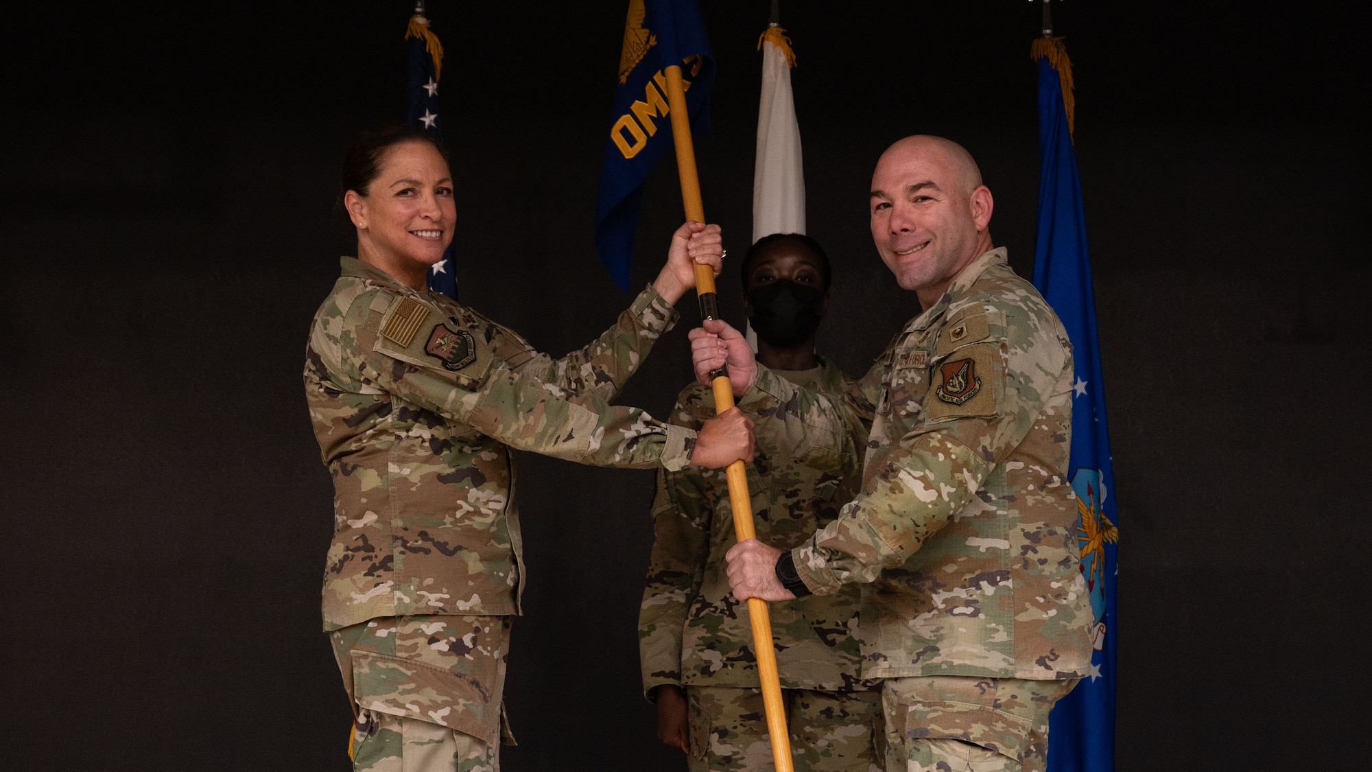 U.S. Air Force Col. Mocha Robinson, 51st Medical Group commander, left, passes the guidon to Lt. Col Darrick Duran, incoming 51st Operational Medical Readiness Squadron commander, right, at Osan Air Base, Republic of Korea, June 17, 2025. Previously, Duran served as the Deputy Commander, 347th Mission Support Group, Yokota AFB, Japan, where he led 2,800 military and civilian personnel across six squadrons and one geographically separated flight and managed over $7 billion in assets. (U.S. Air Force photo by Senior Airman Rome Bowermaster)