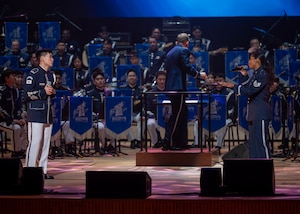 Republic of Korea Air Force Airman 1st Class Hwang Hwi-Hyon, ROKAF Band member, left, and U.S. Air Force Staff Sgt. Sierra Kukan, U.S. Air Force Band of the Pacific member, right, sing during the annual Air Force Band Concert at the Korean Broadcasting System Hall in Seoul, Republic of Korea, June 12, 2025. Their performance symbolized unity and mutual respect  between the PACAF and ROKAF bands. (U.S. Air Force photo by Staff Sgt. Sarah Williams)