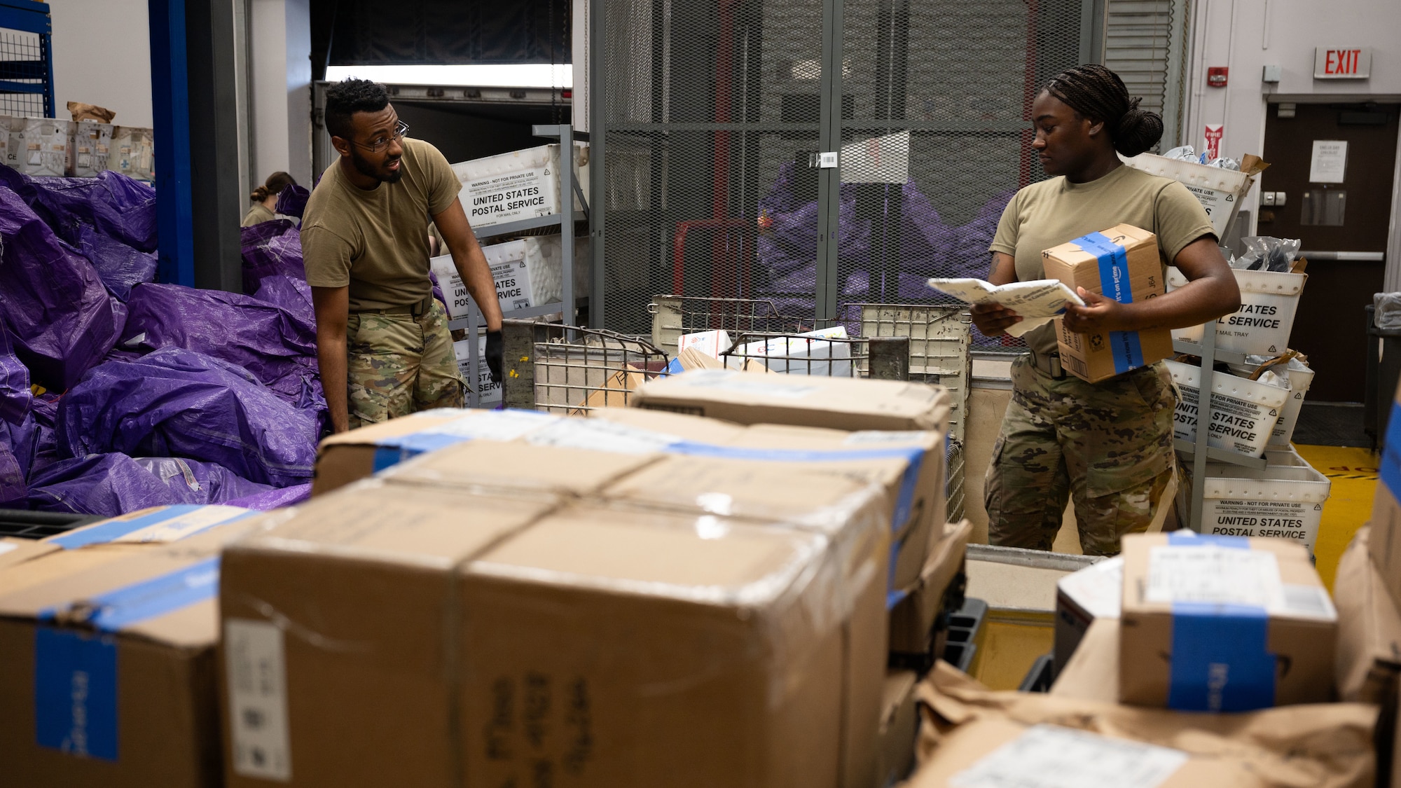 U.S. Air Force Senior Airman Evant Sayles, left, and Airman 1st Class Naviyah Taylor, 51st FSS military postal clerks, sort packages at Osan Air Base, Republic of Korea, June 16, 2025. Hundreds of packages travel through the post office every day, delivering essential items to military personnel and families. (U.S. Air Force photo by Senior Airman Rome Bowermaster)