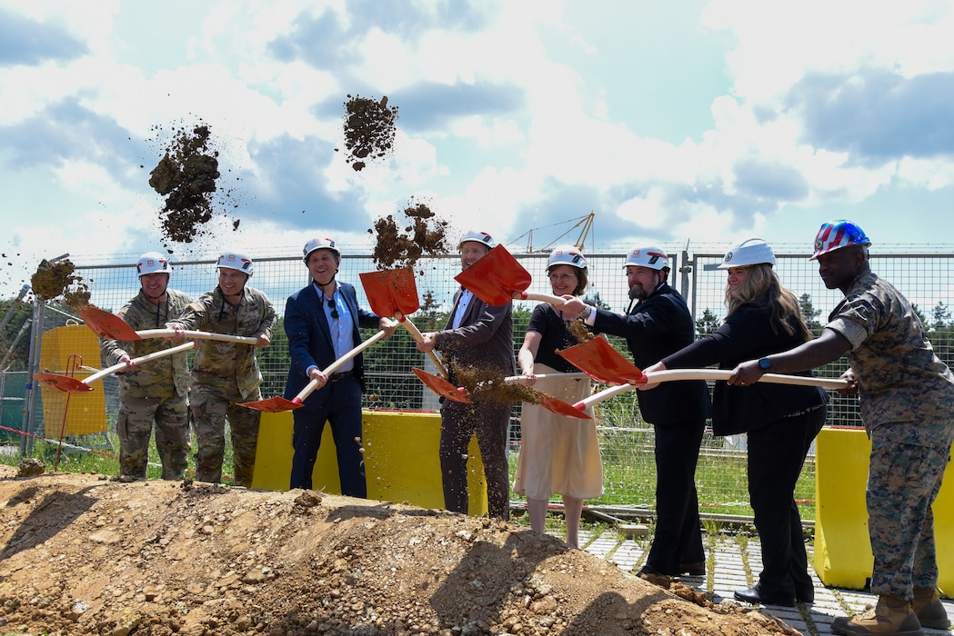 smiling people with shovels flinging dirt into the air