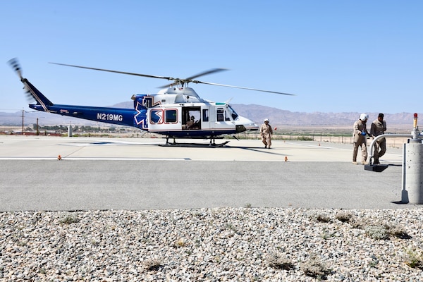An air medical evacuation helicopter touches down on the helipad at Naval Hospital Twentynine Palms during the Semper Durus 2025 regional training exercise, May 21. As part of the simulated mass casualty scenario—staged in coordination with Marine Corps Air Ground Combat Center (MCAGCC) and other base tenants—the aircraft transported two role-playing Marines with critical injuries sustained in a notional explosion and friendly fire incident on Range 112. Emergency Department personnel awaited the inbound casualties, activating the hospital’s Mass Casualty Protocol and preparing to receive, triage, and stabilize patients as part of the hospital’s comprehensive response. The exercise tested the hospital’s ability to coordinate with partner agencies under pressure and underscored the importance of rapid decision-making, interagency communication, and real-world readiness (U.S. Navy photo by Christopher C. Jones, NHTP/NMRTC Twentynine Palms public affairs officer).