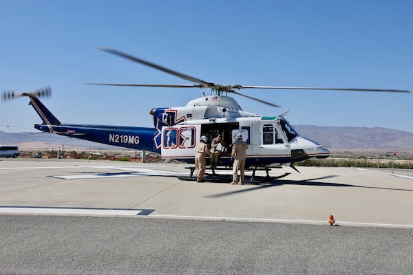 An air medical evacuation helicopter touches down on the helipad at Naval Hospital Twentynine Palms during the Semper Durus 2025 regional training exercise, May 21. As part of the simulated mass casualty scenario—staged in coordination with Marine Corps Air Ground Combat Center (MCAGCC) and other base tenants—the aircraft transported two role-playing Marines with critical injuries sustained in a notional explosion and friendly fire incident on Range 112. Emergency Department personnel awaited the inbound casualties, activating the hospital’s Mass Casualty Protocol and preparing to receive, triage, and stabilize patients as part of the hospital’s comprehensive response. The exercise tested the hospital’s ability to coordinate with partner agencies under pressure and underscored the importance of rapid decision-making, interagency communication, and real-world readiness (U.S. Navy photo by Christopher C. Jones, NHTP/NMRTC Twentynine Palms public affairs officer).
