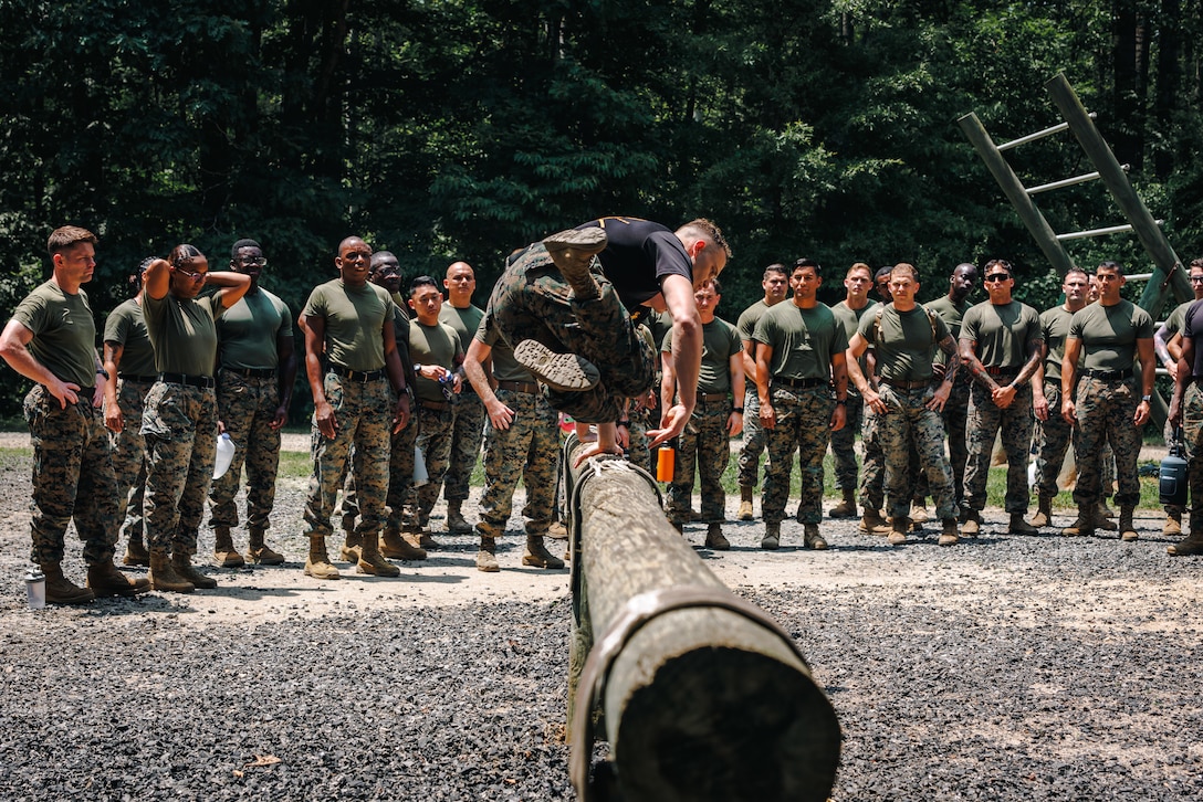 Students with Force Fitness Instructor Course 3-25 receive a demonstration of a bunny hop while conducting the obstacle course at The Basic School on Marine Corps Base Quantico, Virginia, June 12, 2025. The FFI course trains Marines to improve their warfighting capability to maximize unit physical readiness and optimize mental and physical performance. (U.S. Marine Corps photo by Lance Cpl. Braydon Rogers)