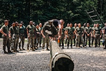 Students with Force Fitness Instructor Course 3-25 receive a demonstration of a bunny hop while conducting the obstacle course at The Basic School on Marine Corps Base Quantico, Virginia, June 12, 2025. The FFI course trains Marines to improve their warfighting capability to maximize unit physical readiness and optimize mental and physical performance. (U.S. Marine Corps photo by Lance Cpl. Braydon Rogers)