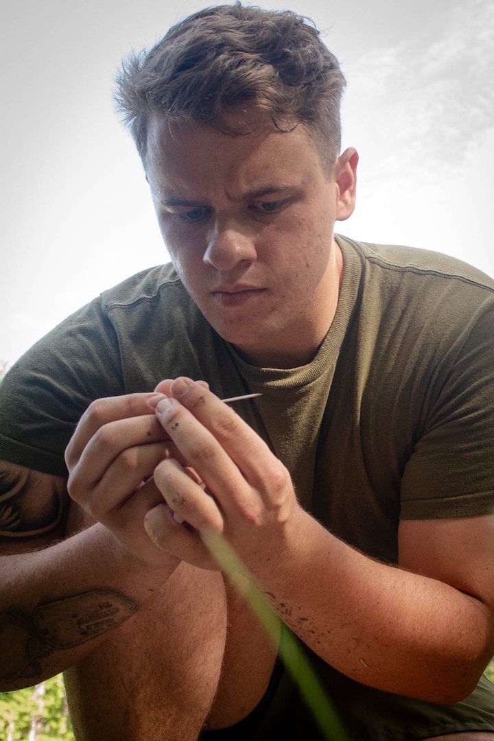Hospitalman Matthew Gill, a Sailor assigned to the 2nd Marine Aircraft Wing’s Warrior Wellness and Readiness clinic, inspects an IV needle before inserting it into a training aid during the Corpsman Cup held Friday, June 13 aboard Marine Corps Air Station Cherry Point.  The event tested the Corpsmen’s’ tactical medical skills, mental resilience and physical fitness through various stations.