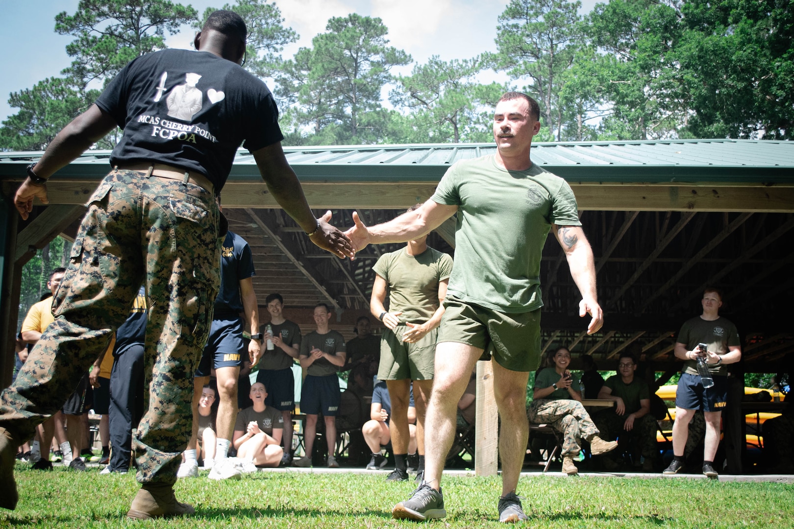 Hospital Corpsman Second Class Jon Cericola, a Sailor assigned to 2nd Marine Aircraft Wing’s Warrior Wellness and Readiness Clinic receives congratulations for holding a plank for five minutes, fifty-one seconds to win the Corpsman Cup for his team during a tie-breaker event.  The Corpsman Cup, held Friday, June 13 aboard Marine Corps Air Station Cherry Point, tested the Sailors tactical medical skills, mental resilience and physical fitness through various stations.