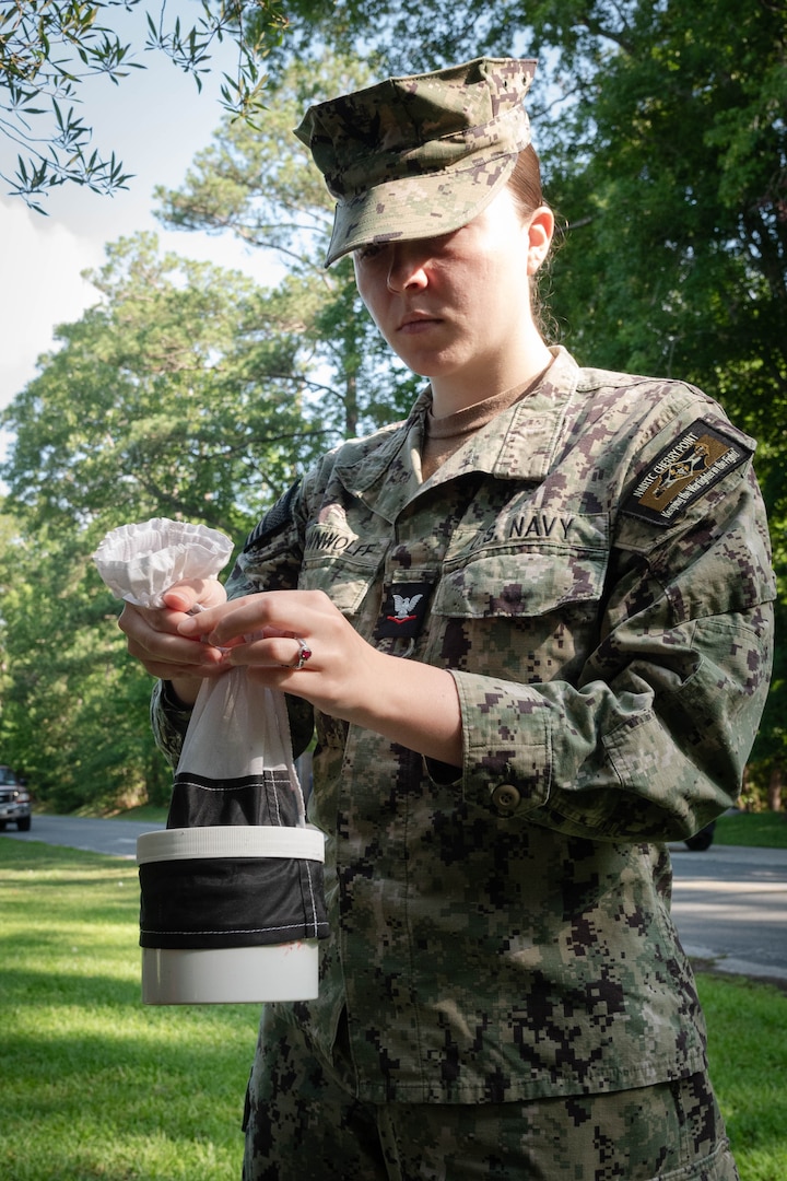 Hospital Corpsman Third Class Nikki Brown Wolff retrieves a mosquito trap Thursday, June 12, 2025, at Marine Corps Air Station Cherry Point. Assigned to Naval Health Clinic Cherry Point’s Preventive Medicine Department, Brown Wolff, a native of Las Vegas, Nevada, helps monitor mosquito populations to protect the base’s staff, residents and service members from disease. Collected mosquitoes are frozen and counted to assess their prevalence.