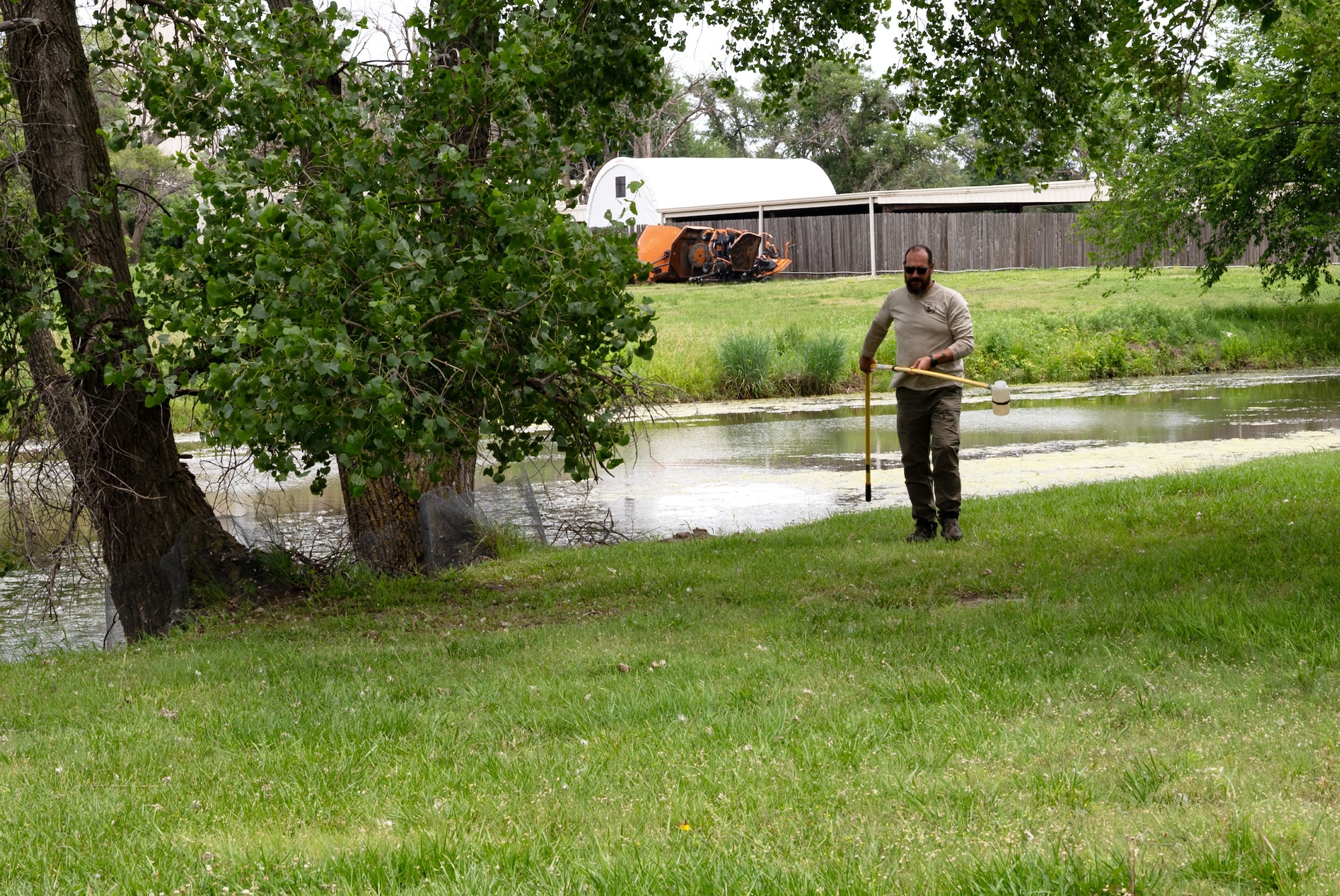 Nick King, U.S. Fish and Wildlife Service (FWS) wildlife biologist, obtains a sample of water from a creek for an environmental DNA test of alligator snapping turtles June 11, 2025, at McConnell Air Force Base, Kansas. The water was strained through a filter membrane to trap DNA, which will be mailed to the FWS Laboratory for testing, as alligator snapping turtles are now an endangered species. (U.S. Air Force photo by Staff Sgt. Tryphena Mayhugh)