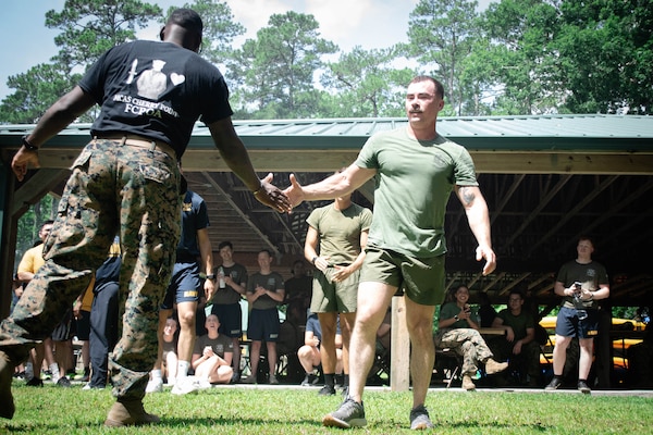 Hospital Corpsman Second Class Jon Cericola, a Sailor assigned to 2nd Marine Aircraft Wing’s Warrior Wellness and Readiness Clinic receives congratulations for holding a plank for five minutes, fifty-one seconds to win the Corpsman Cup for his team during a tie-breaker event.  The Corpsman Cup, held Friday, June 13 aboard Marine Corps Air Station Cherry Point, tested the Sailors tactical medical skills, mental resilience and physical fitness through various stations.