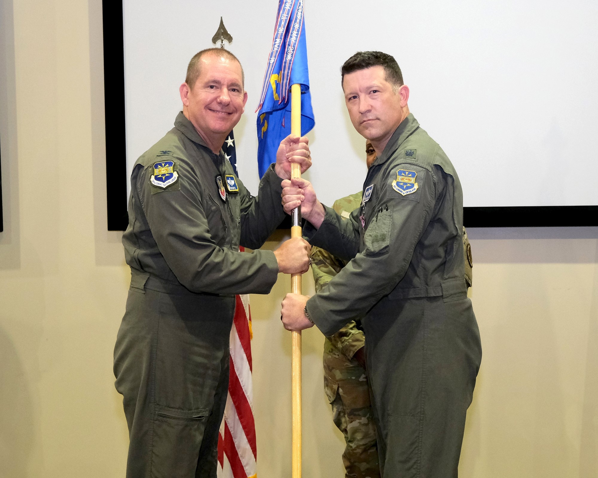 photo of two US Airmen holding a unit flag