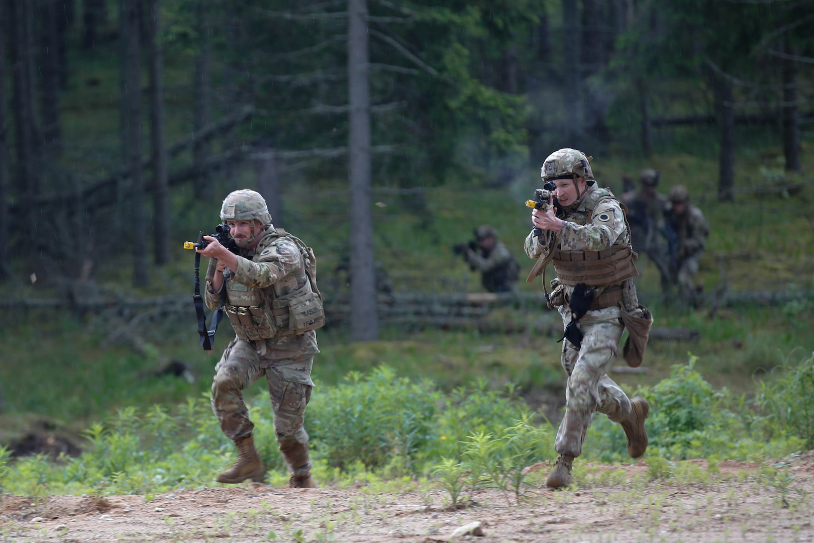 U.S. Army Spc. Jade Hozak-Valdez, (left), and Spc. Anthony Broesma, assigned to Charlie Company, 1st Battalion, 125th Infantry Regiment, Michigan Army National Guard, run towards the trenches during Exercise Baltic Viking near Alūksne, Latvia, June 8, 2025.