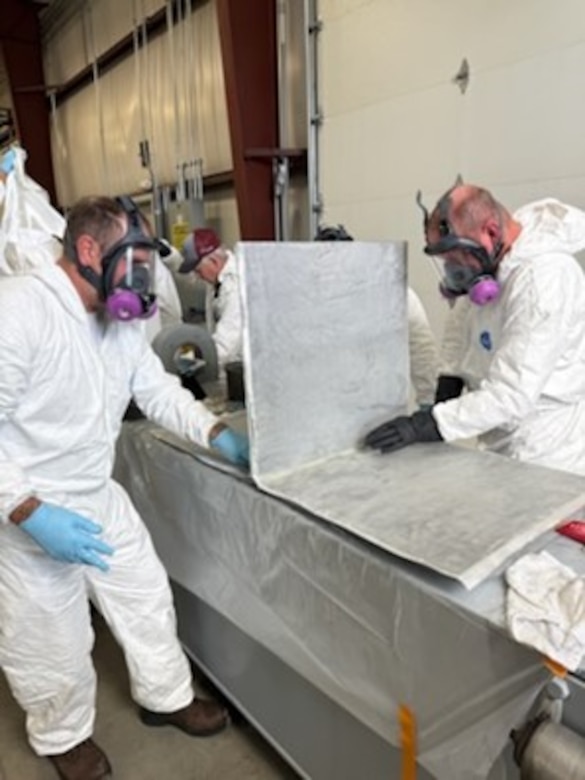 Fiber Reinforced Polymer (FRP) Installation certification attendees apply FRP material to the steel ‘T’ section, which represents the anticipated orientation and positioning of repairs, to strengthen the fractured critical members of Gate 3’s upper leaf.