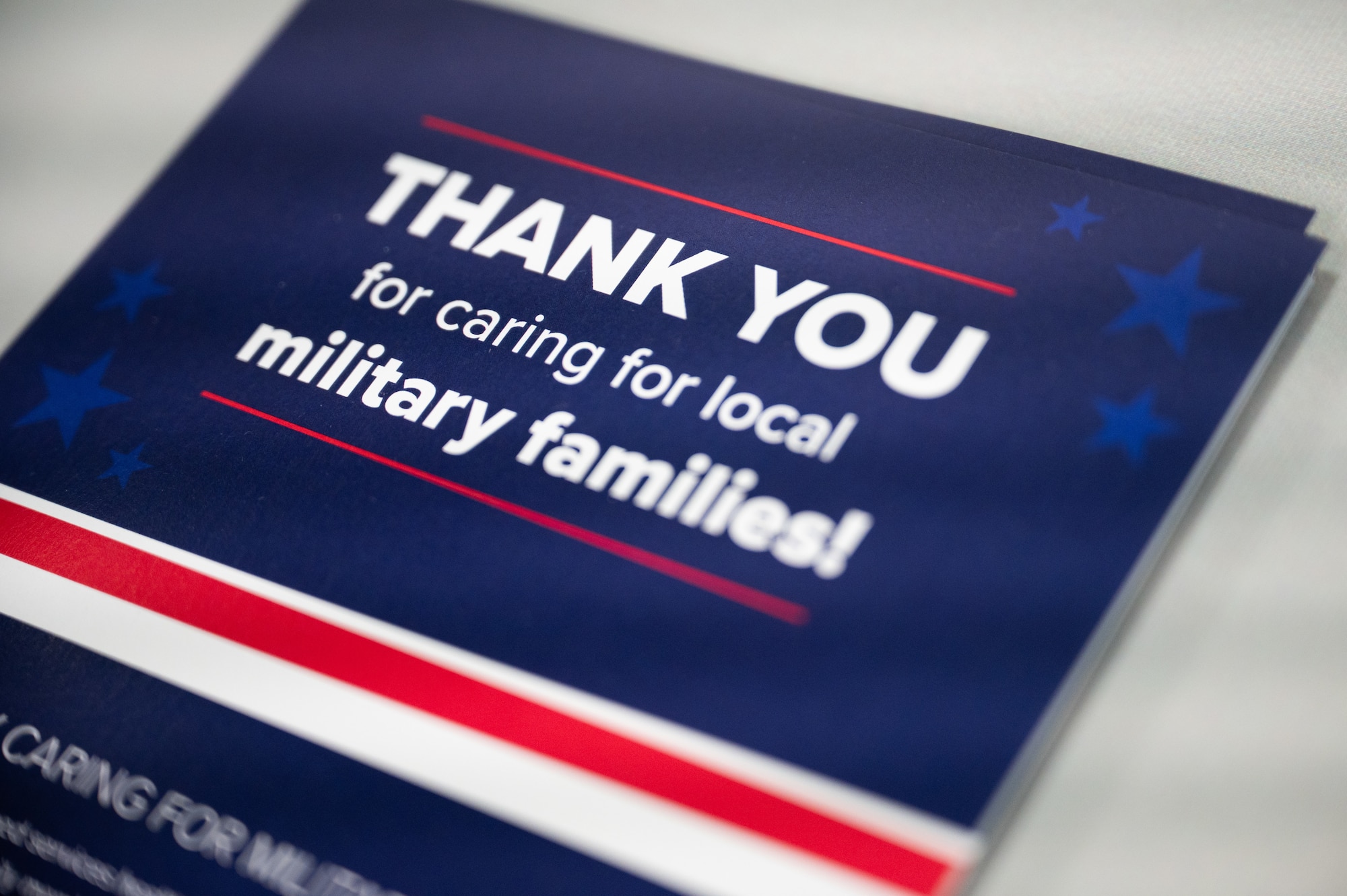 A TRICARE pamphlet sits on a table. The text reads: "Thank you for caring for local military families!"