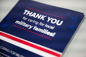 A TRICARE pamphlet sits on a table. The text reads: "Thank you for caring for local military families!"