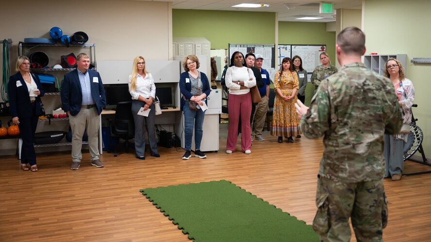 An Airman speaks to a tour group of civilian medical providers inside Minot Air Force Base's physical therapy center.
