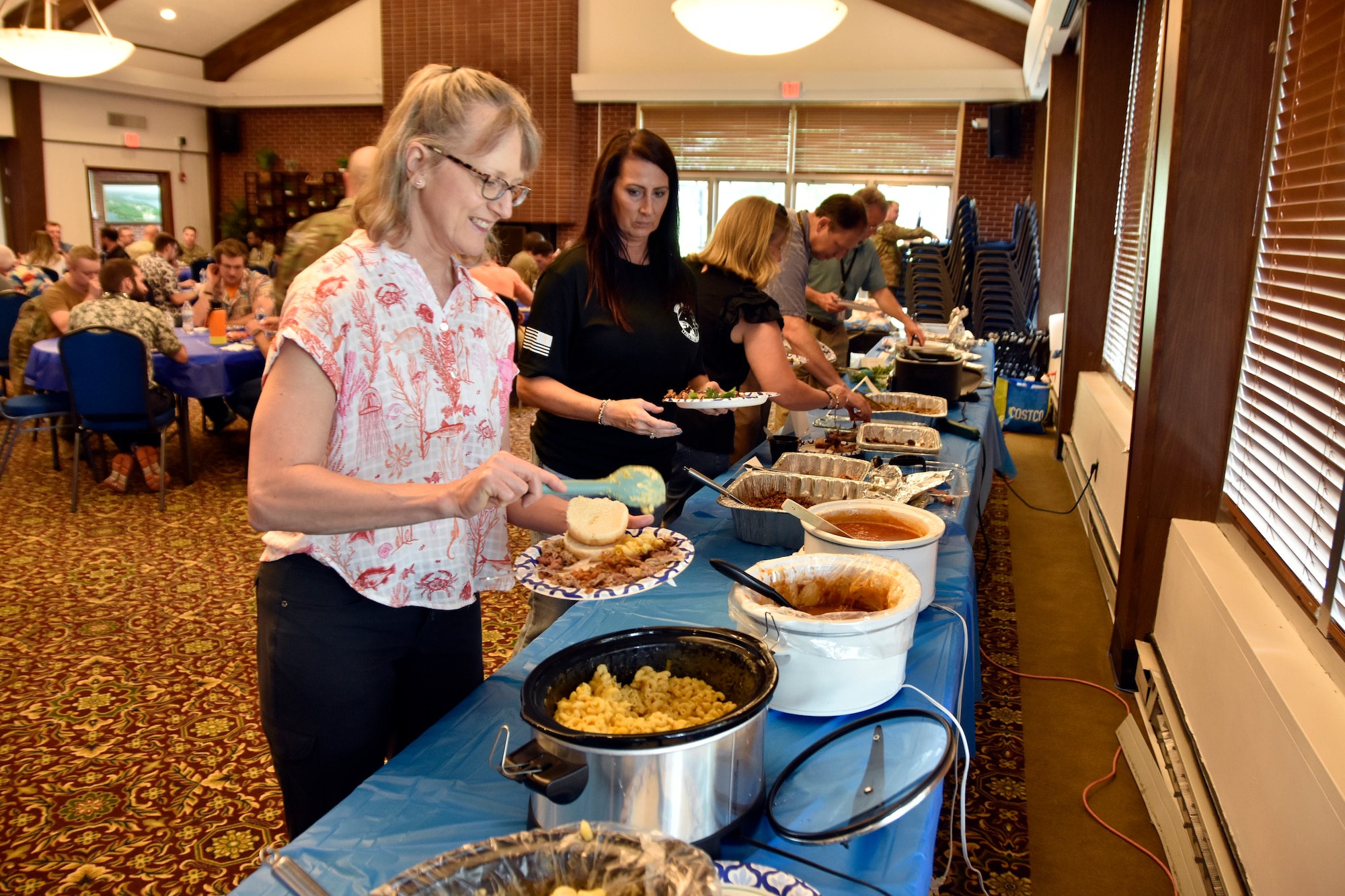 Becky Morris, 804th Test Group administrative assistant adds to her plate during the 804th Test Group BBQ Cookoff, June 6, 2025, at the Arnold Lakeside Complex on Arnold Air Force Base, Tenn. During the annual event, several members of the 804th Test Group team vie for the coveted large wooden fork, the trophy given to the cookoff victor, by preparing barbecue which is not only shared with colleagues across the test group, but also judged by several others on the 804TG team. (U.S. Air Force photo by Bradley Hicks)