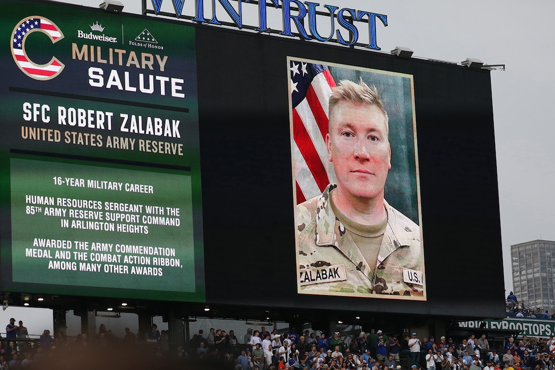 Sgt. 1st Class Robert Zalabak's photo appears on the Wrigley Field jumbotron during a Chicago Cubs Military Salute recognition, June 12, 2025.