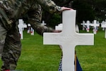 U.S. Army Maj. Michael Kone, assigned to the 29th Infantry Division, cleans the headstone of Maj. Thomas D. Howie, the “Major of St. Lo,” June 5, 2025, at the Normandy American Cemetery in Colleville-sur-Mer, Normandy, France. Howie was a battalion commander in the 29th ID and was killed in action during the Battle of Normandy while leading his men in an effort to capture Saint-Lô. More than 600 U.S. service members, including 30 from the 29th ID, are in Normandy to commemorate the 81st anniversary of the D-Day landings. (U.S. Army National Guard photo by Sgt. 1st Class Terra C. Gatti)